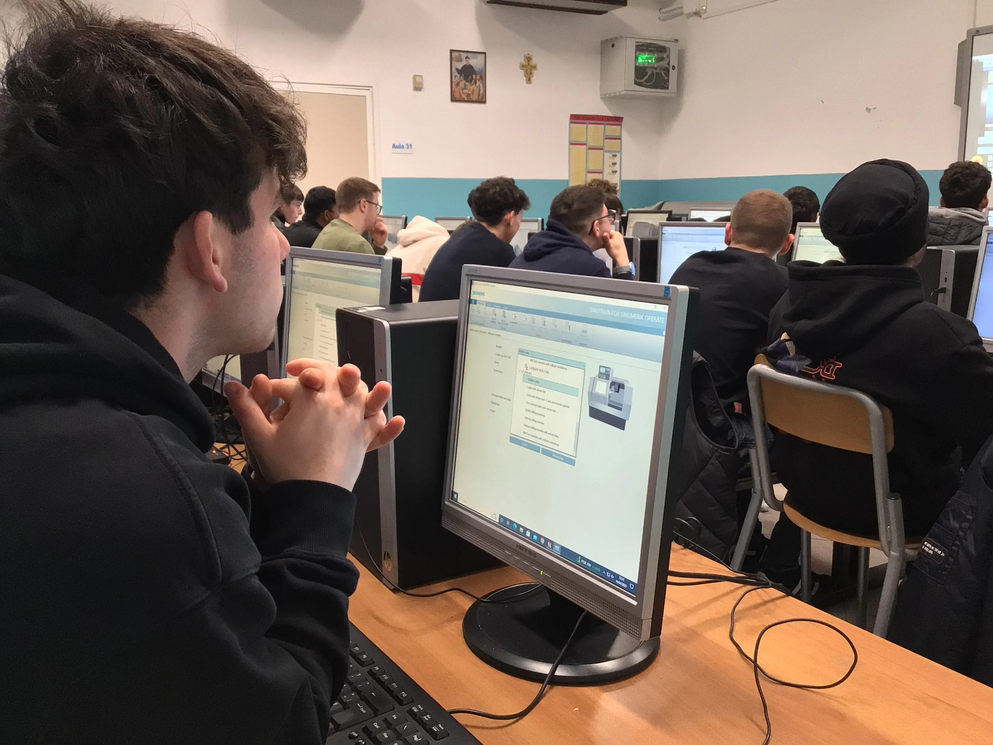 Ragazzi lavorano alla prototipazione di manufatti utilizzando un software specifico.