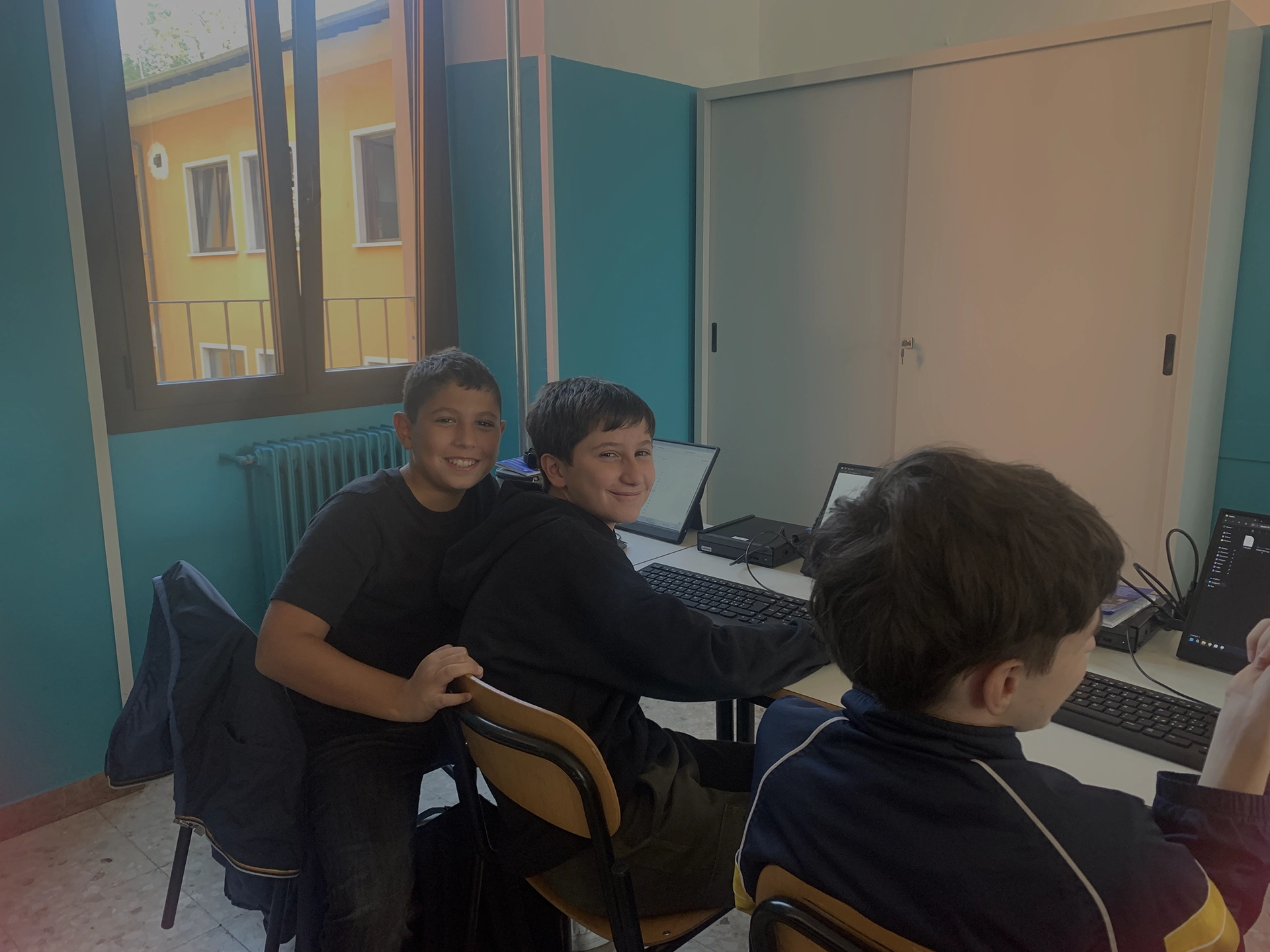 Tre ragazzi in aula davanti ai computer