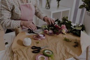 Operatrice nell'atto di realizzare un mazzo di fiori