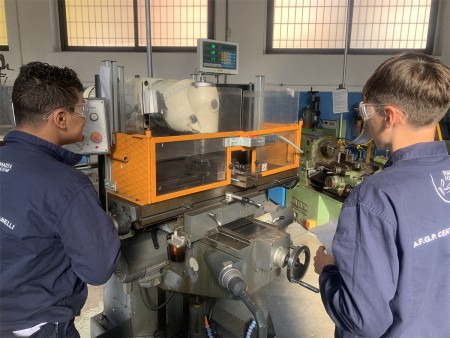 Studenti che operano una fresatrice in laboratorio.
