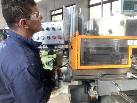 Studente che utilizza una fresatrice nel laboratorio scolastico.