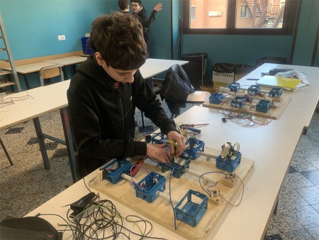Studente impegnato nel cablaggio di un impianto elettrico durante un'esercitazione pratica in laboratorio.