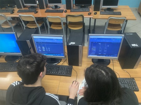  Due studenti lavorano insieme su un progetto tecnico utilizzando un software CAD su un computer, impegnati nella creazione di un disegno tecnico o schema.