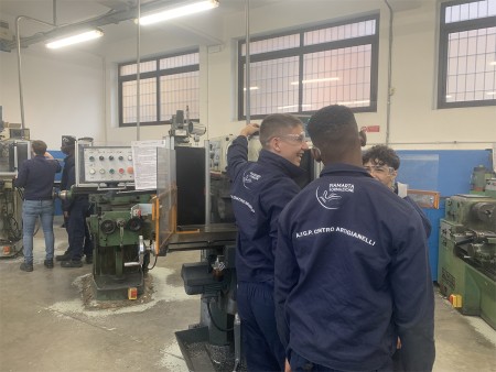 Un gruppo di studenti indossa tute da lavoro con il logo 